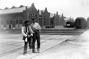 1894. aasta Chicago Pullmani streigi ajal seisavad Pullmani hoone kõrval kaks teenindajat ja rongivad lukustatud relvade ja pudeli likööriga autosid.