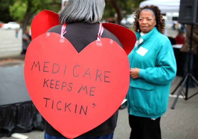 Naine, kes kannab südamekujulist silti " Medicare hoiab mind tiksumas"