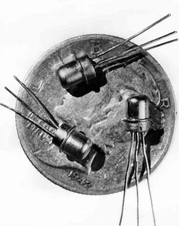 1956. aasta pilt kolmest miniatuursest M-1 transistorist, mida nähti peenraha ees