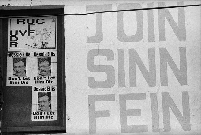 Plakatid Põhja-Iirimaal, mis toetavad erakonda Sinn Fein ja võrdlevad Põhja-Iiri politseijõude Briti armeega.