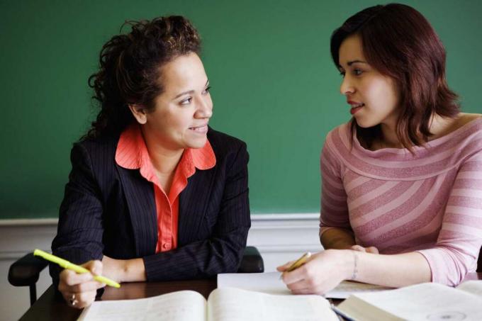 Estudiante y professor hablando en un aula.